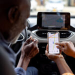 Two people using an iPhone in a car.