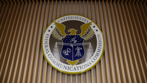 Photo of the Federal Communications Commission's insignia on the wall of the agency's briefing room.