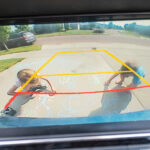 Children seen in a backup camera view from a vehicle