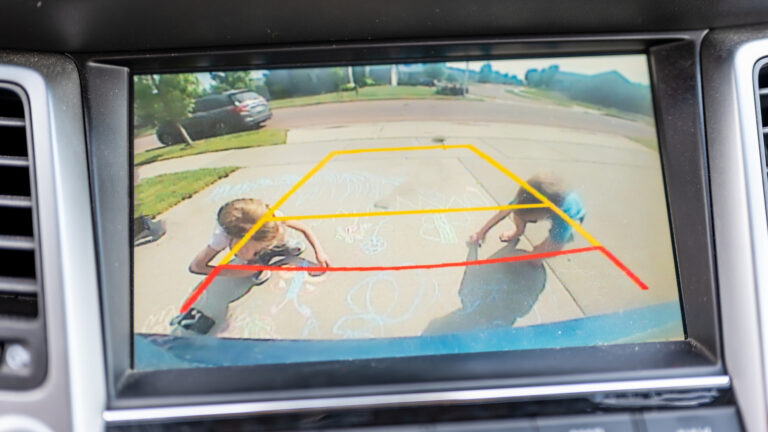 Children seen in a backup camera view from a vehicle