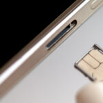 A SIM card being put into a smartphone using its tray.